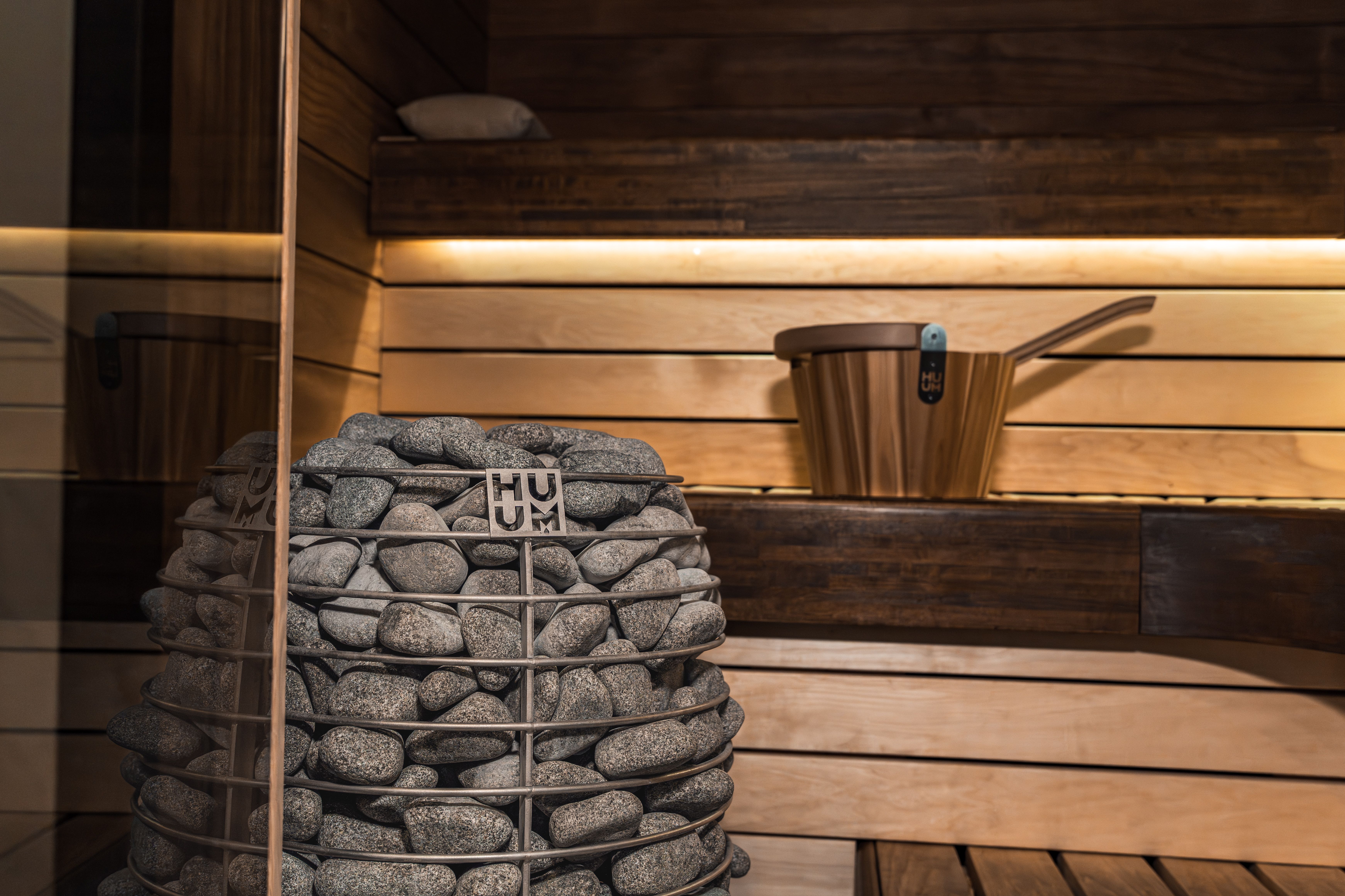 A sleek and modern wooden sauna with a stone heater, showcasing Nordic design and aesthetics.