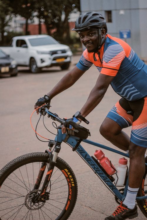 Free Athlete in colorful cycling gear riding mountain bike on urban street, showcasing fitness and lifestyle. Stock Photo