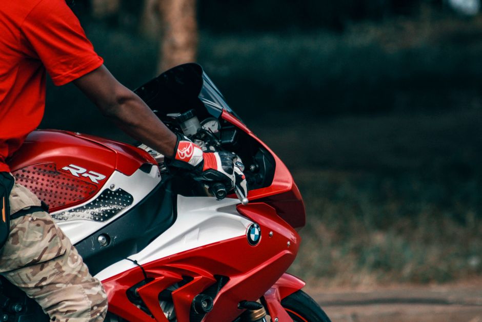 Close-up of a motorcyclist riding a red BMW sports bike outdoors.