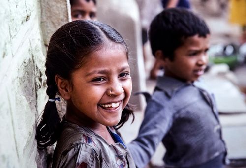 Free A cheerful Indian girl smiles brightly outdoors, capturing childhood joy and innocence. Stock Photo