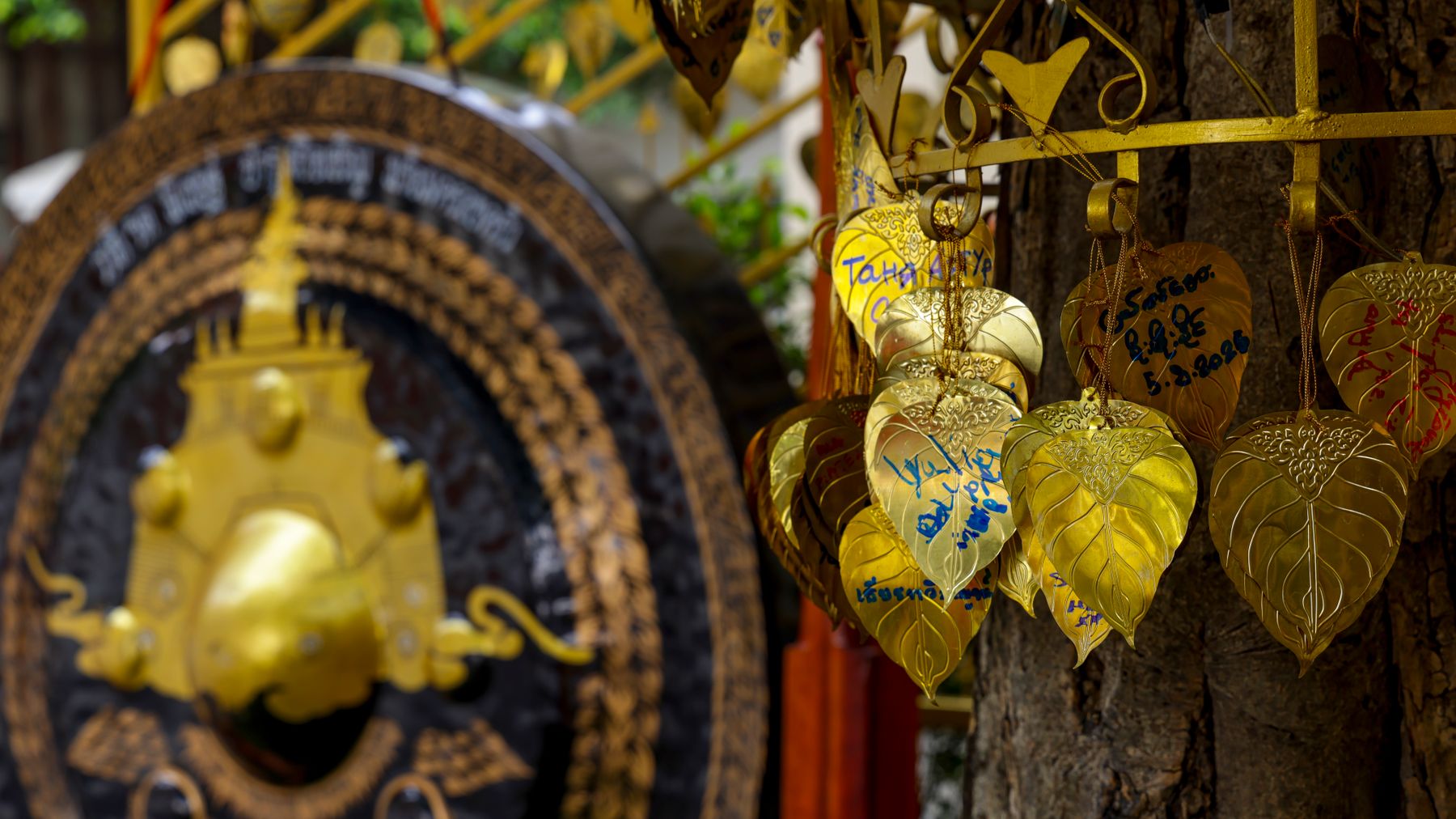 Close-up of golden leaves and gong at a Thai temple in Bangkok, Thailand.