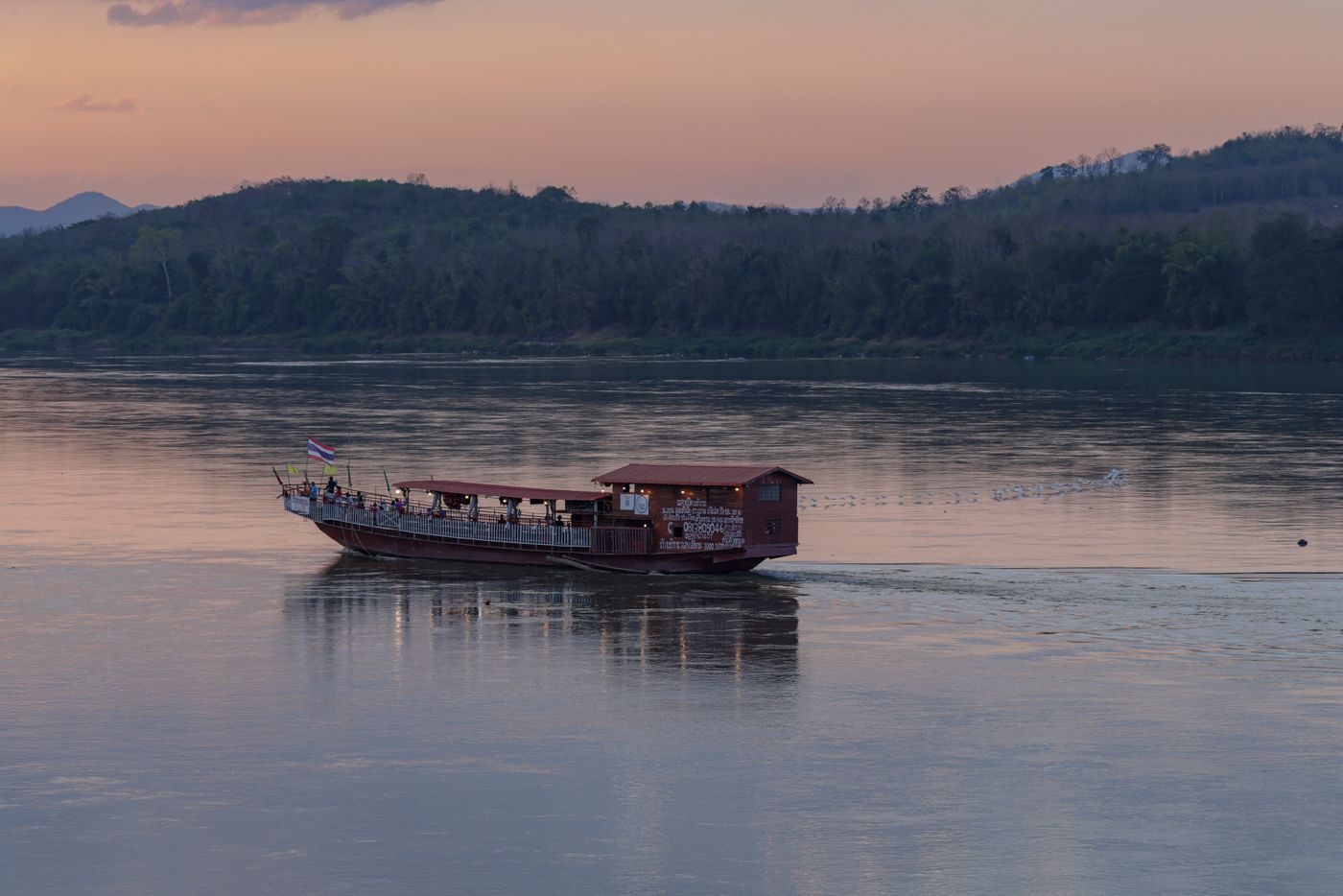 A boat on a calm river at sunset, Cambodia