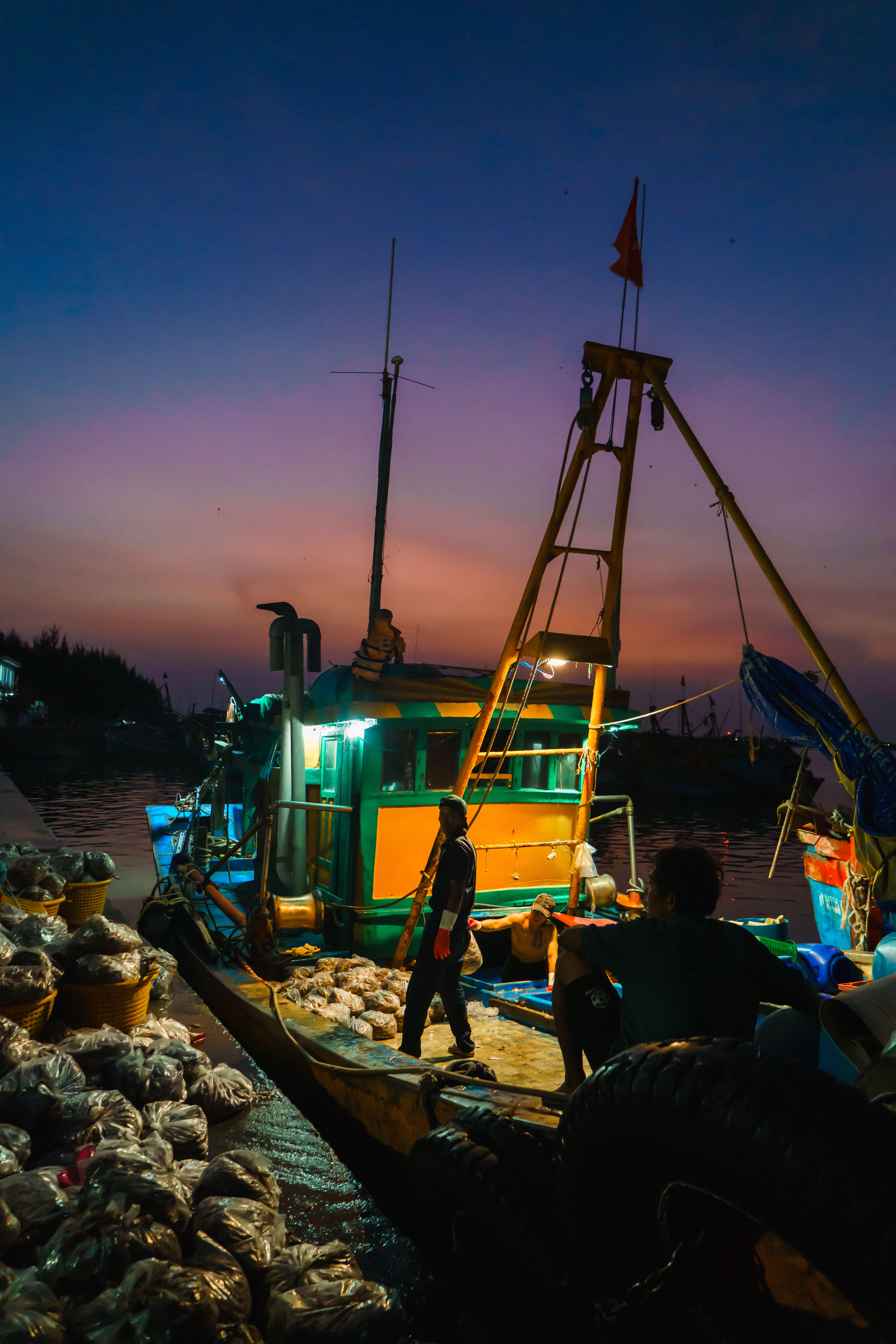 A colorful fishing boat docked at Vũng Tàu harbor during twilight, exemplifying coastal life.