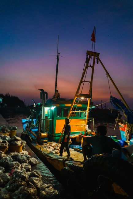 A colorful fishing boat docked at Vũng Tàu harbor during twilight, exemplifying coastal life.