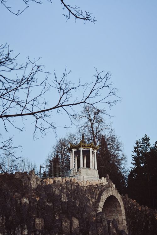 Free Stone pavilion on rocky hilltop surrounded by bare trees in winter setting. Stock Photo