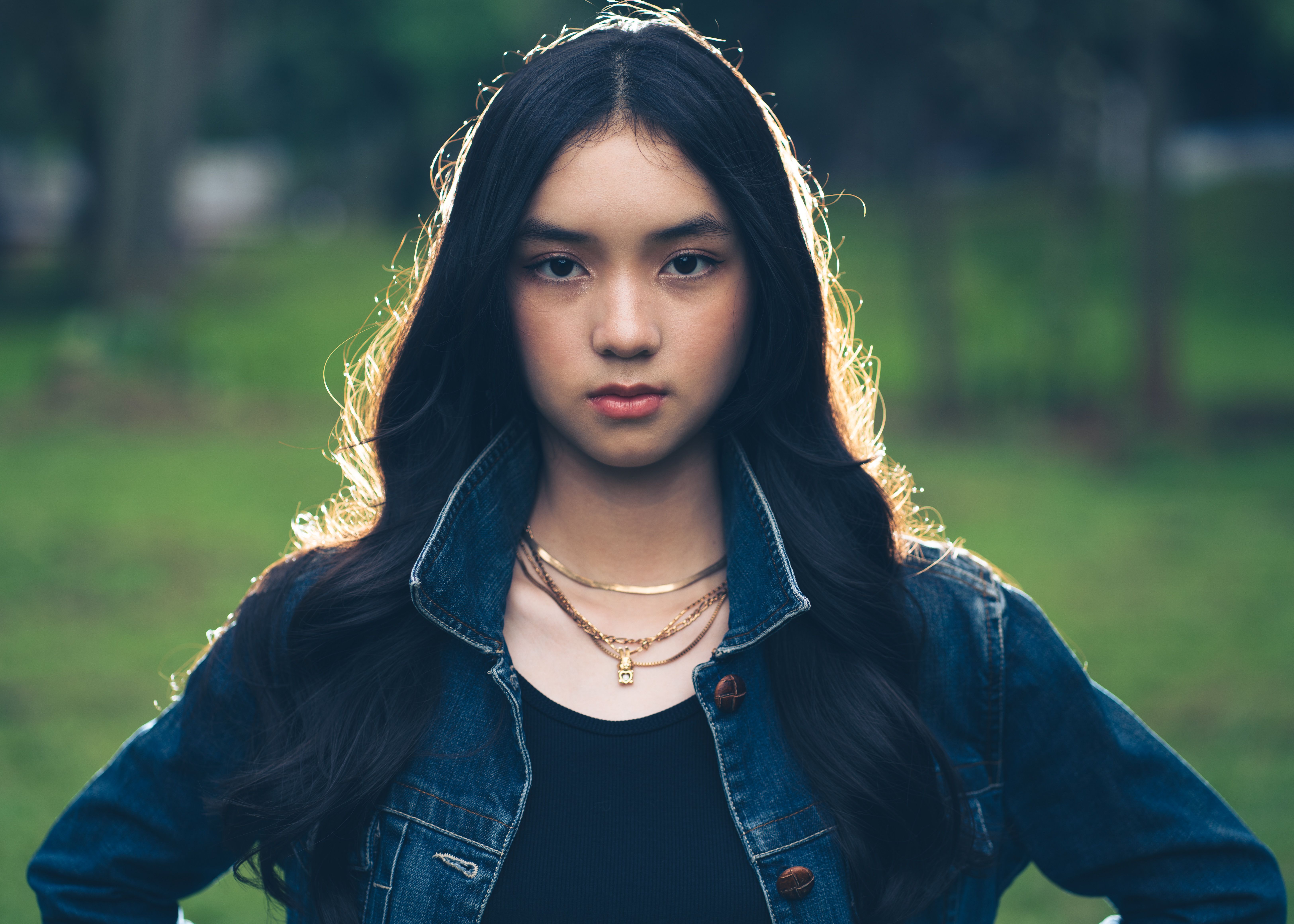 Captivating portrait of a young woman in a park setting, Jakarta, showcasing modern style and natural beauty.