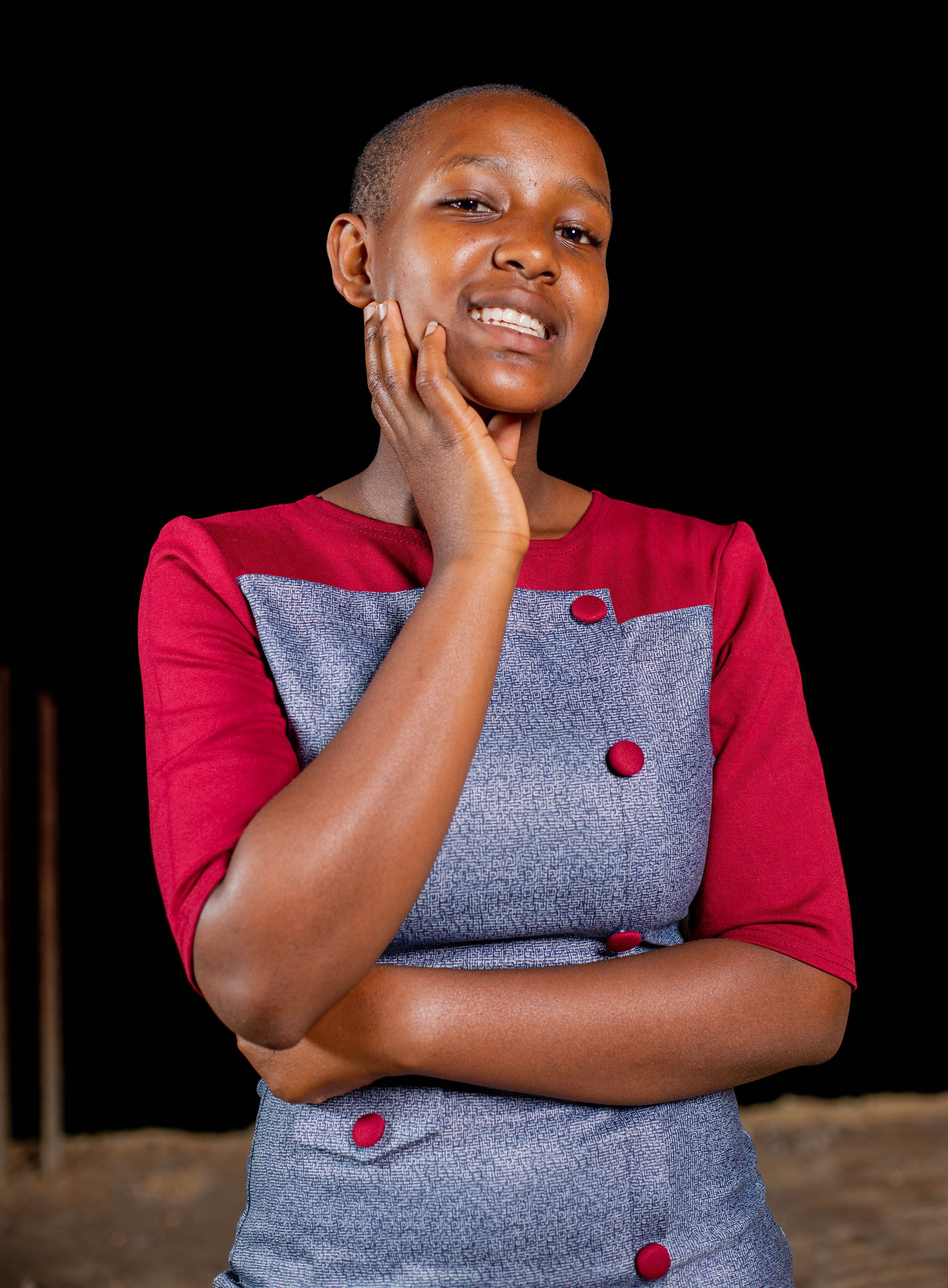 Charming portrait of a smiling woman wearing a stylish dress, set against a dark background.