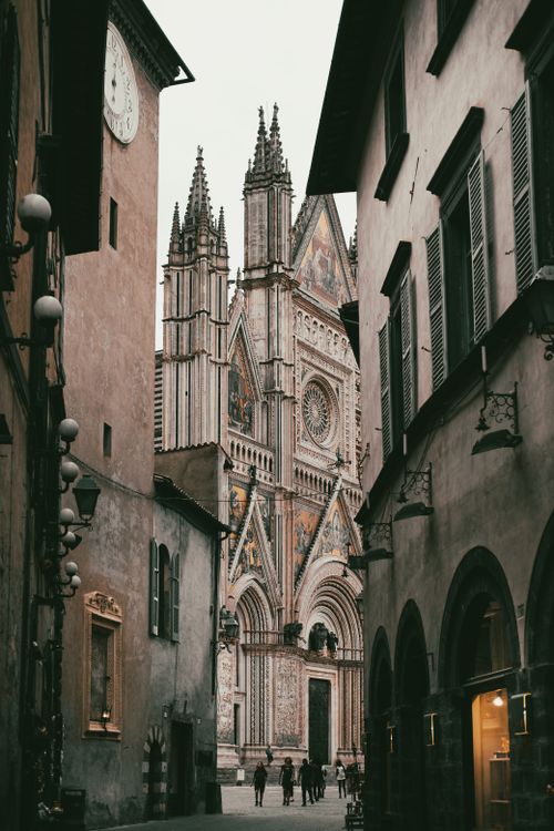 Free Picturesque view of Orvieto Cathedral framed by narrow Italian alley, highlighting Gothic architecture. Stock Photo