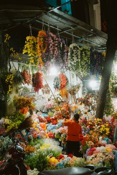 A busy flower market in Hanoi, Vietnam, bustling with colorful blooms and vibrant night life.