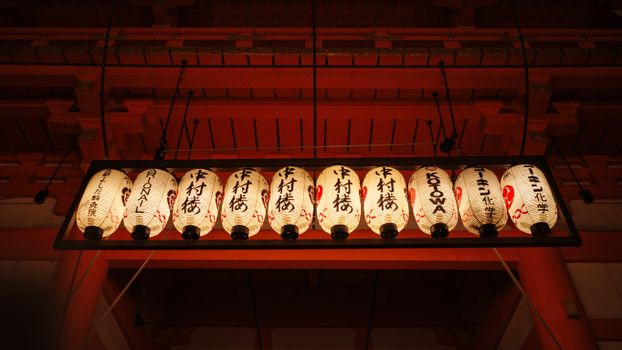 Elegant paper lanterns adorn a Kyoto temple, showcasing traditional Japanese culture and craftsmanship.
