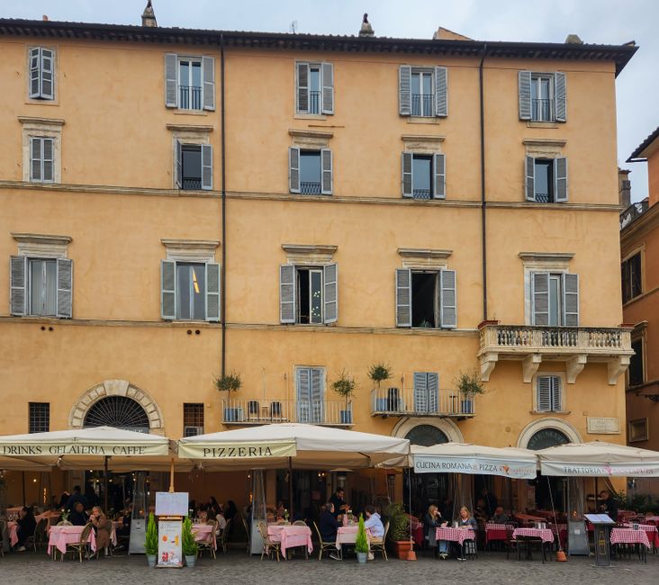 Italian piazza cafe with outdoor seating and traditional yellow building facade