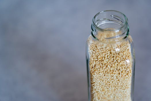 Close-up of a glass jar filled with sesame seeds, perfect for food photography and healthy lifestyle concepts.
