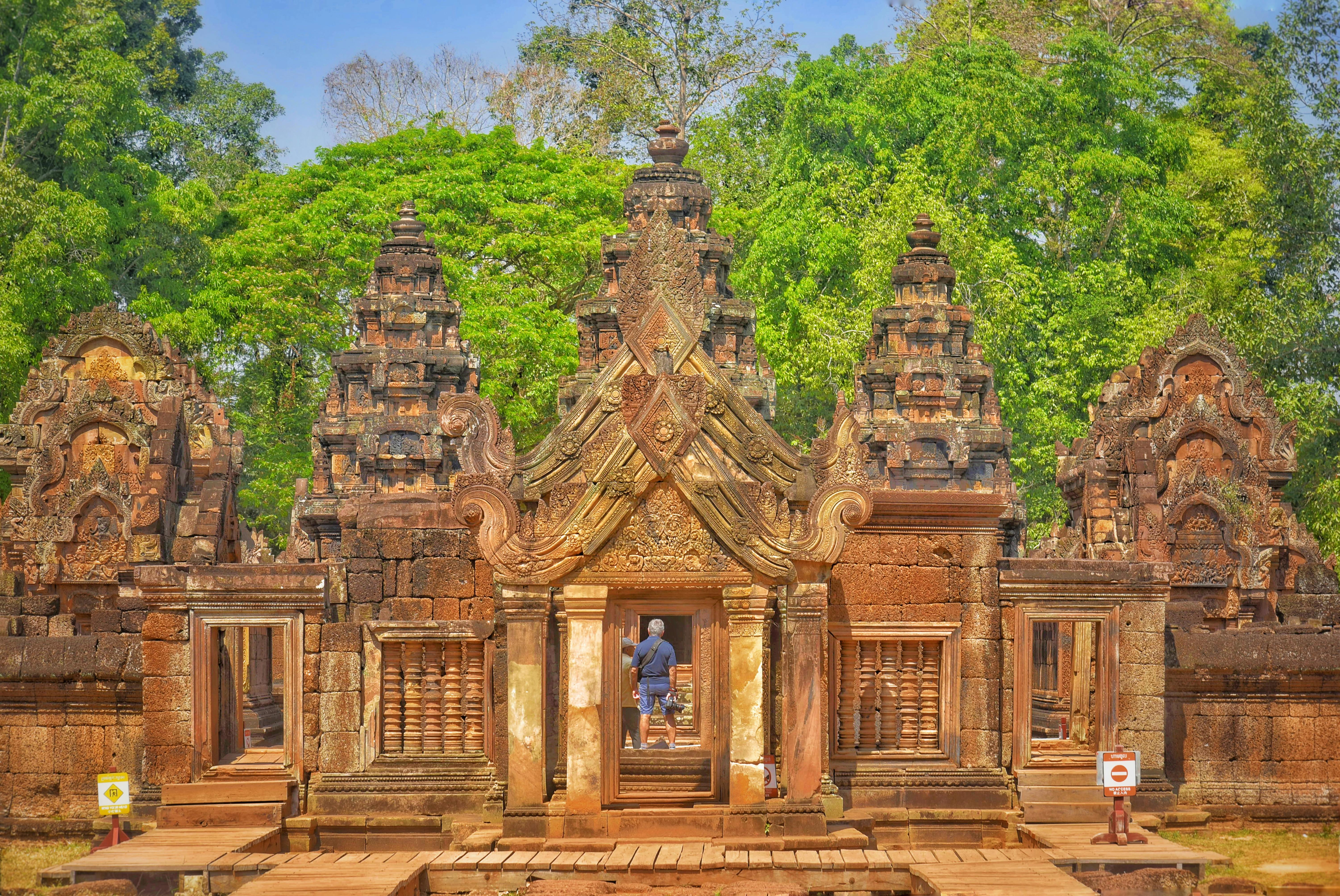 Visitor exploring the intricate architecture of Banteay Srei temple in Cambodia