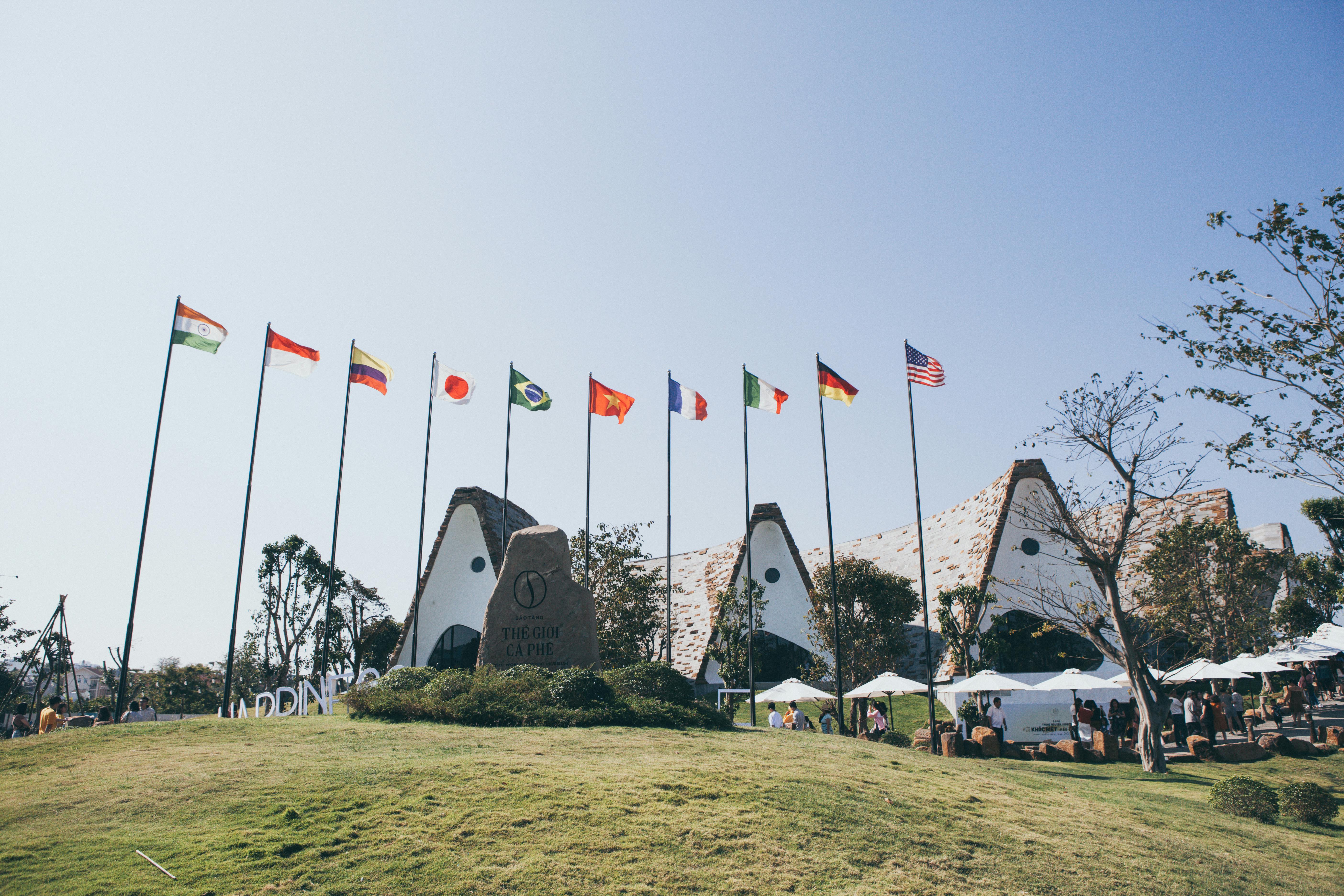 Trung Nguyen Legend Coffee Village with international flags on a sunny day in Buon Ma Thuot, Vietnam.