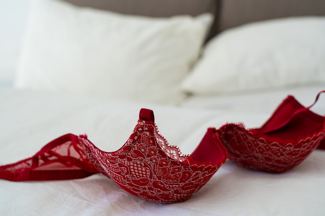 Free Red Lace Brassiere on White Bed Stock Photo
