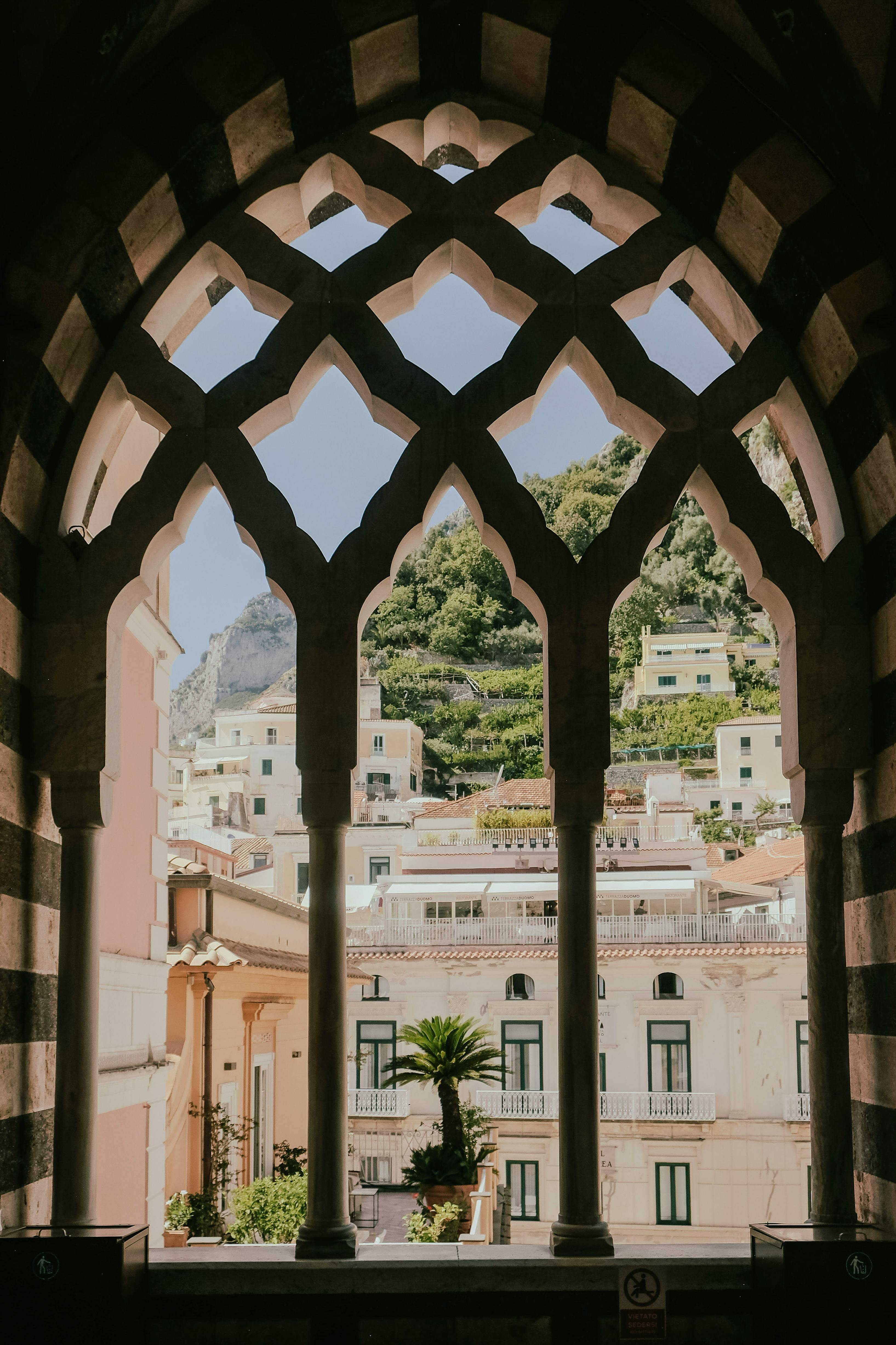 Stunning view of Amalfi's architecture seen through a classic arched window frame.