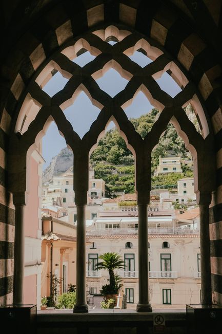Stunning view of Amalfi's architecture seen through a classic arched window frame.