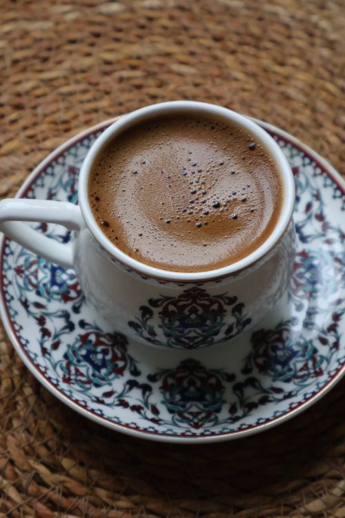 Free A cup of traditional Turkish coffee served in a decorated cup on a woven mat background. Stock Photo