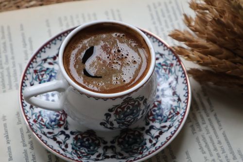 Free A beautifully crafted Turkish coffee in a traditional ceramic cup with floral patterns, featuring wheat decoration. Stock Photo
