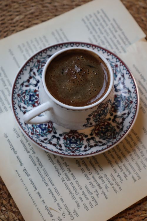 Free Beautiful patterned coffee cup on an open book, perfect for cozy reading moments. Stock Photo