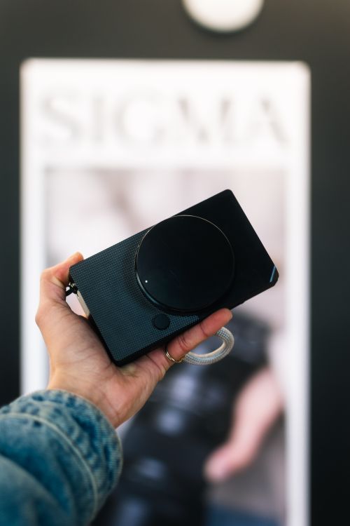 Free Hand holding a compact camera with blurred background, ideal for photography themes. Stock Photo