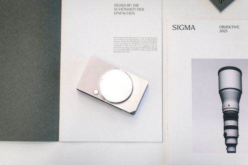 Free A sleek camera on design-themed magazines showcasing modern photography technology. Stock Photo
