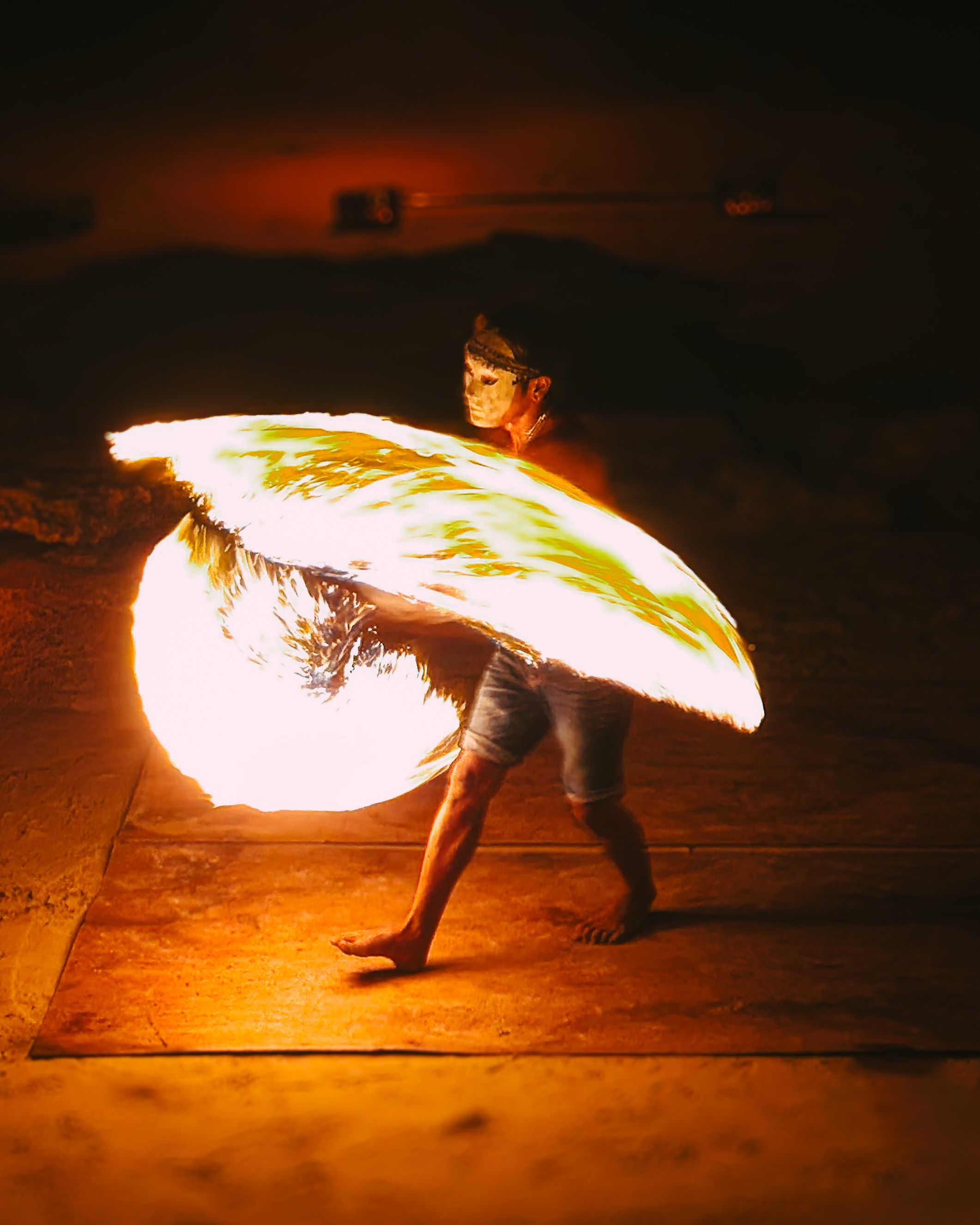 Dazzling fire dancer spins flames during a nighttime show in Thailand.