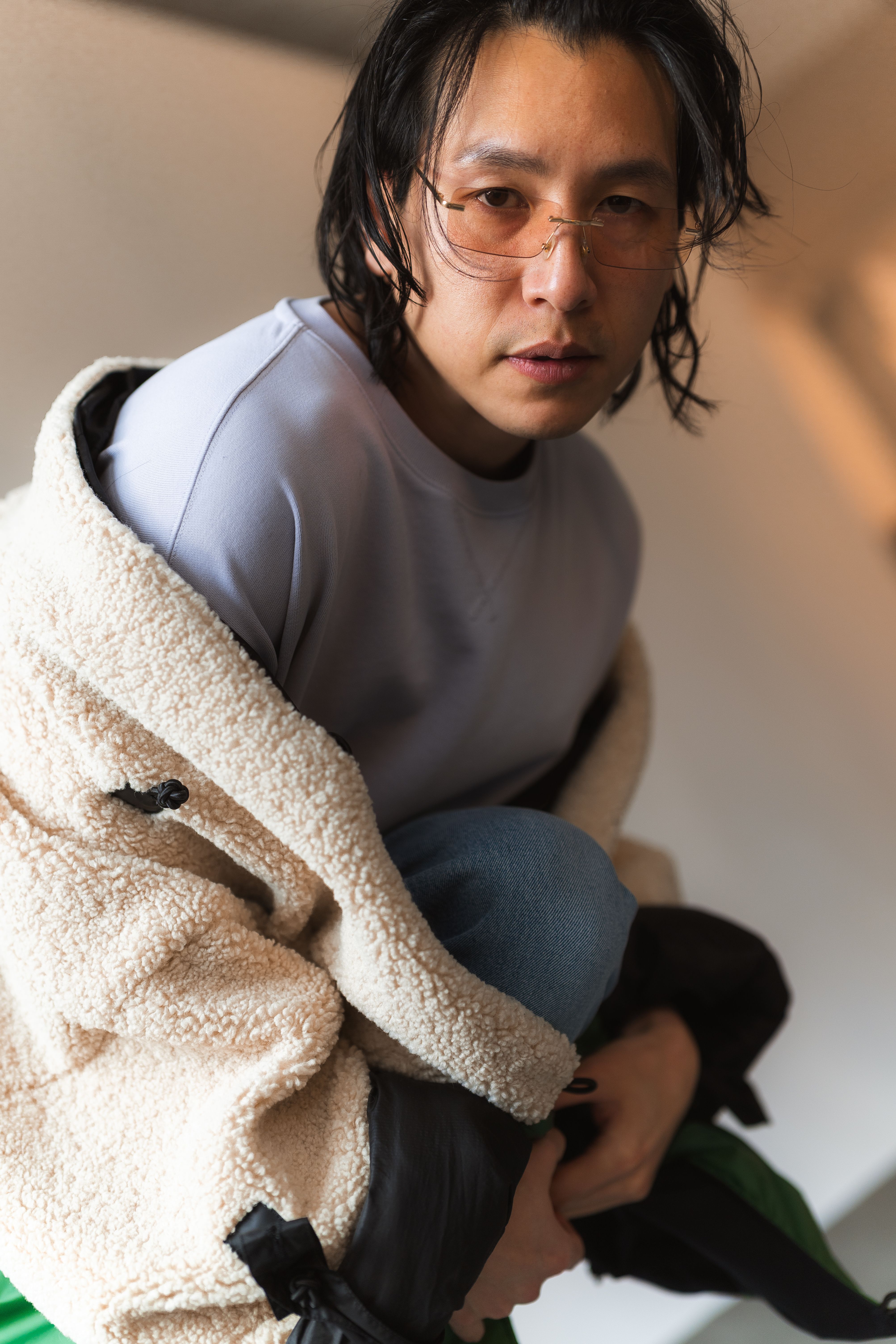 Stylish young adult wearing casual attire and glasses indoors. Trendy urban look.