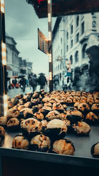 A bustling street market scene with roasted chestnuts for sale in vibrant İstanbul, Türkiye.