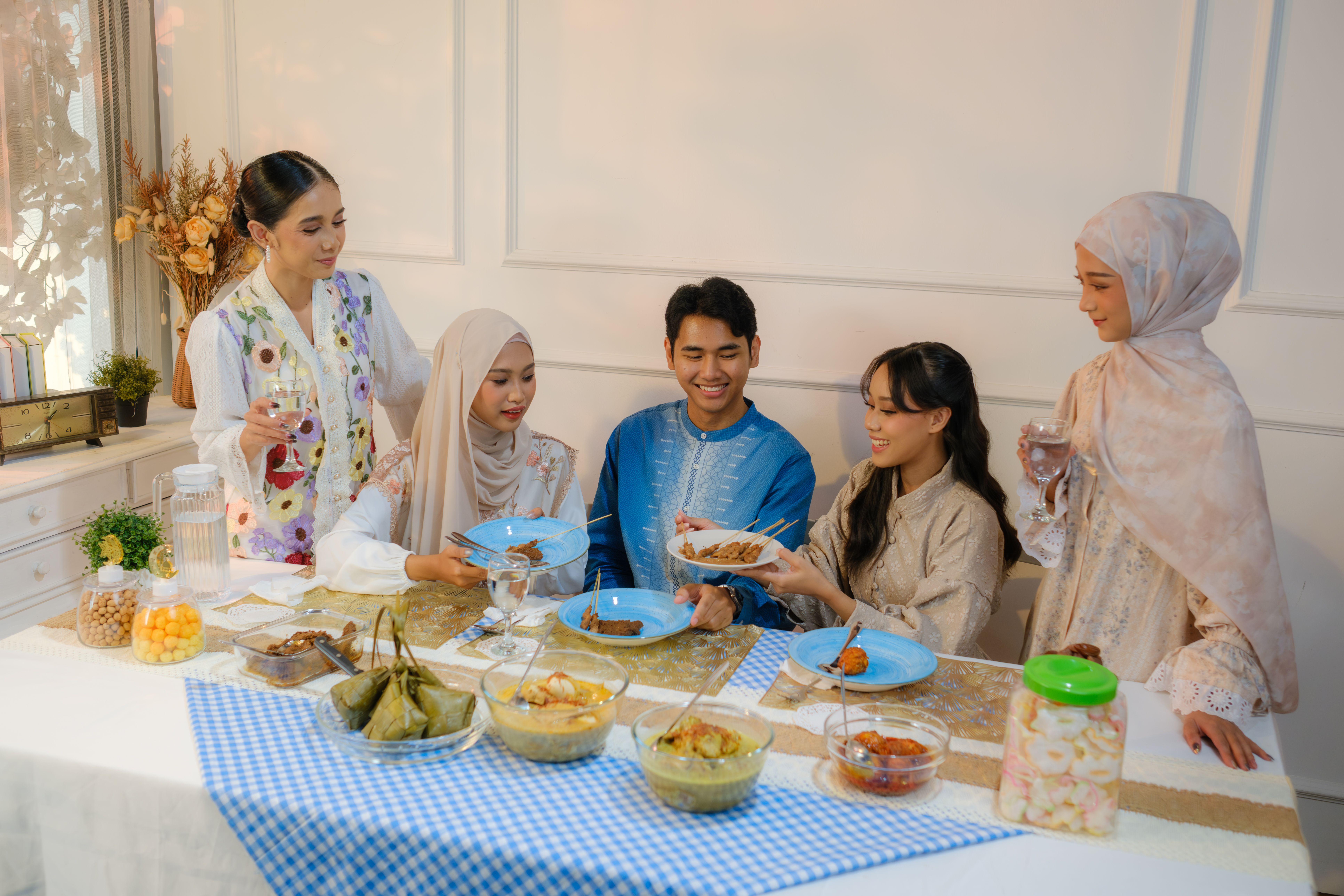 Indonesian family in Jakarta enjoying Eid celebration with traditional festive meal.