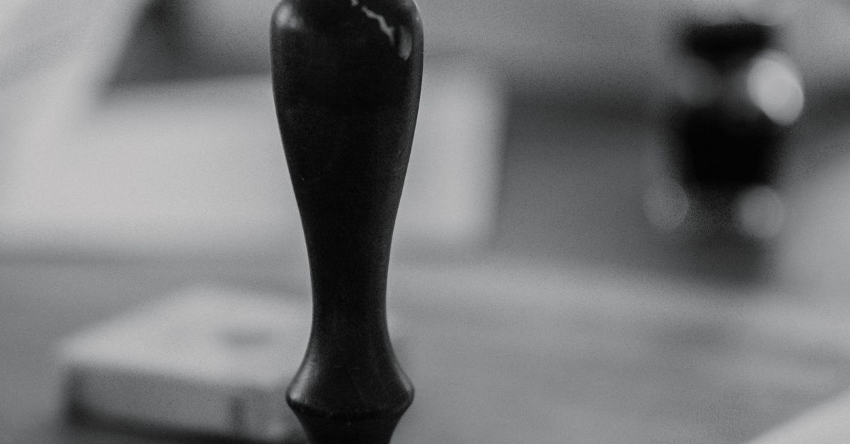 Black and white image of a traditional wax seal with an envelope.