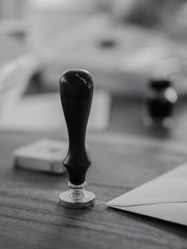 Black and white image of a traditional wax seal with an envelope.