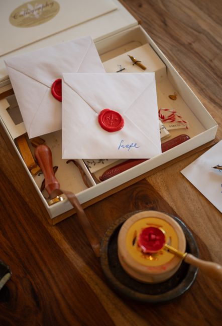 Stylish wax-sealed envelopes with a sealing kit on a wooden table, perfect for vintage correspondence themes.