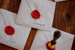 Elegant white envelopes sealed with wax on a wooden table, perfect for invitations.