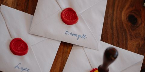 Elegant white envelopes sealed with wax on a wooden table, perfect for invitations.