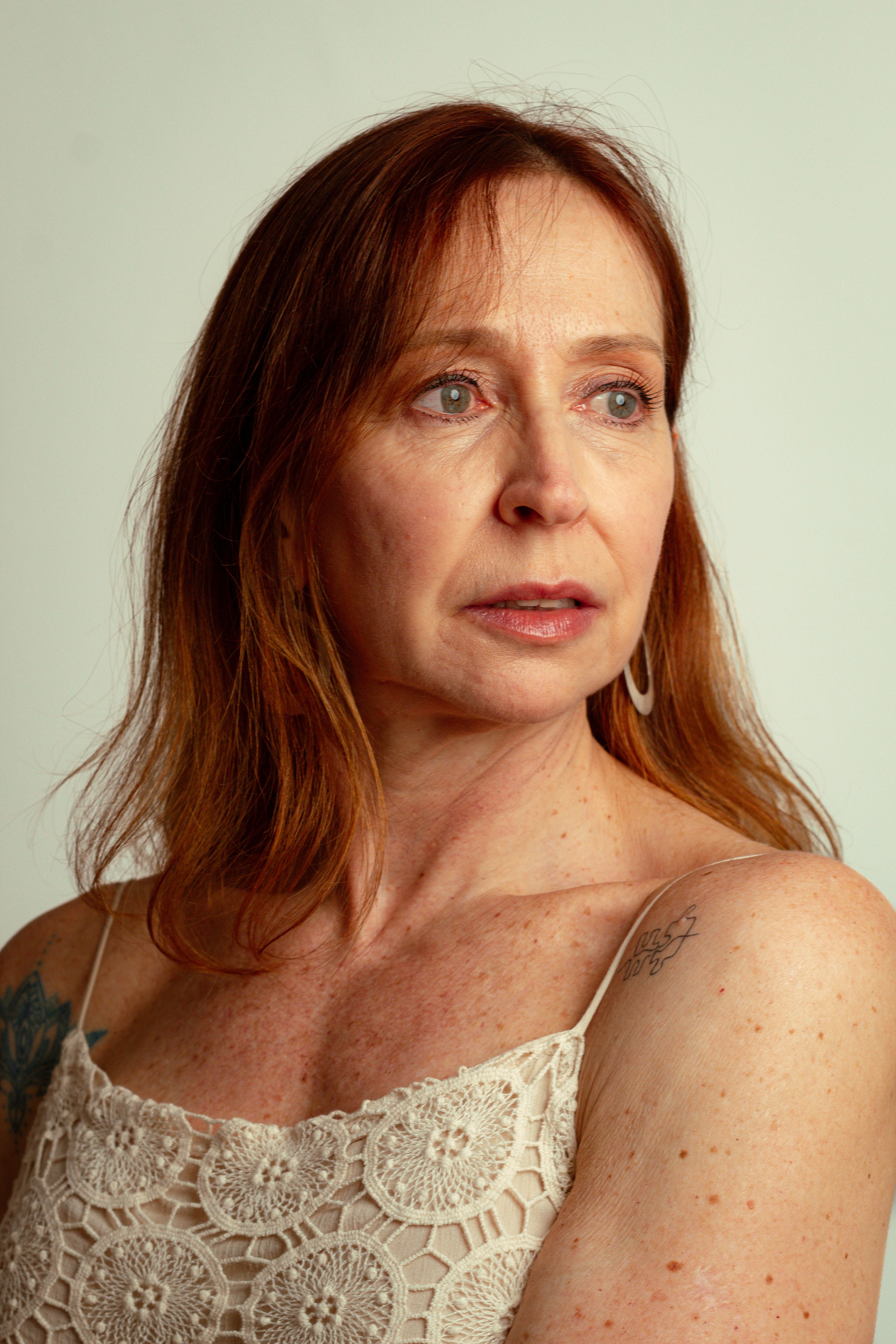 Insightful portrait of a mature woman with red hair and ginger features, expressing depth and emotion.