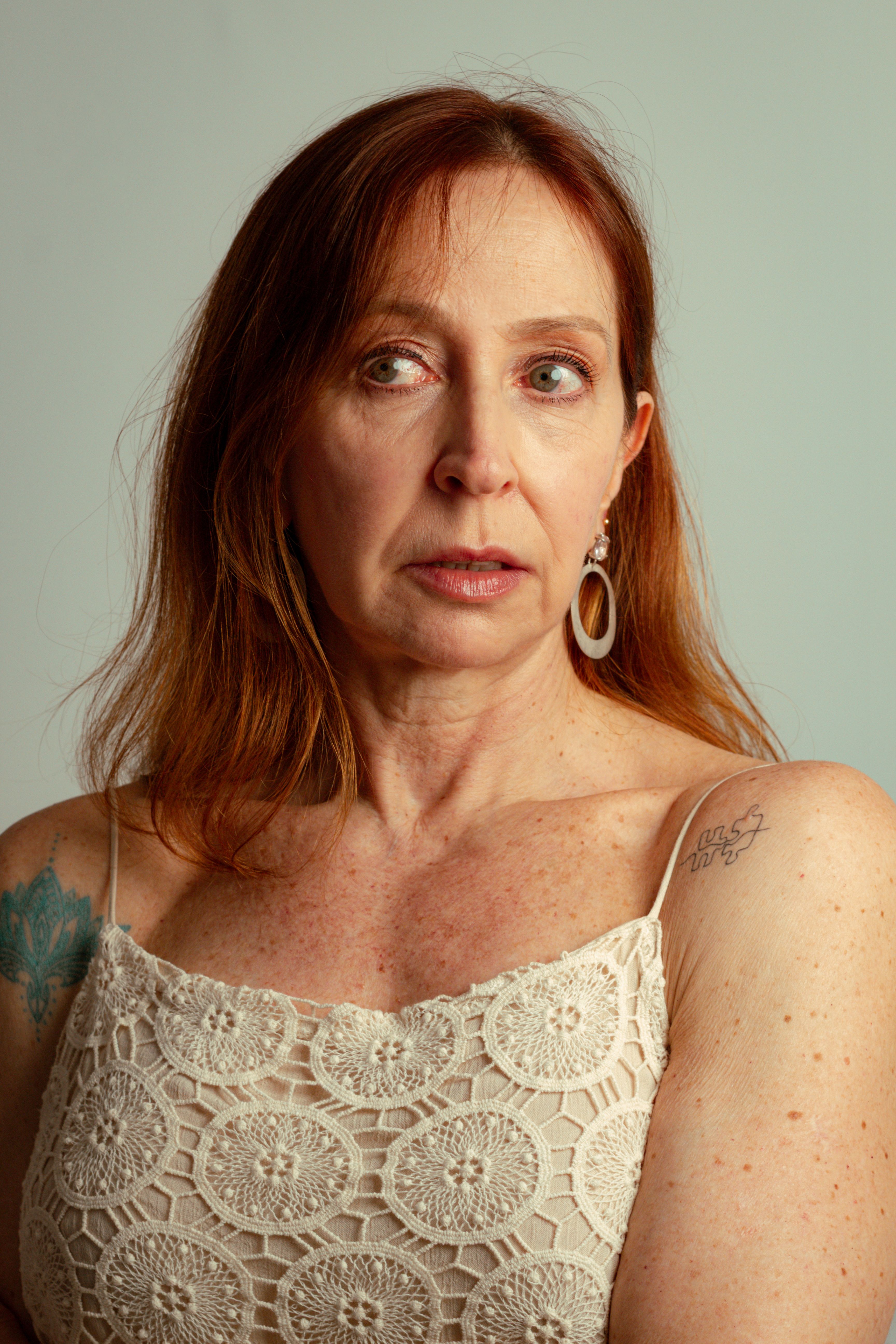 Elegant portrait of a woman with ginger hair and tattoos in São Paulo, Brazil.