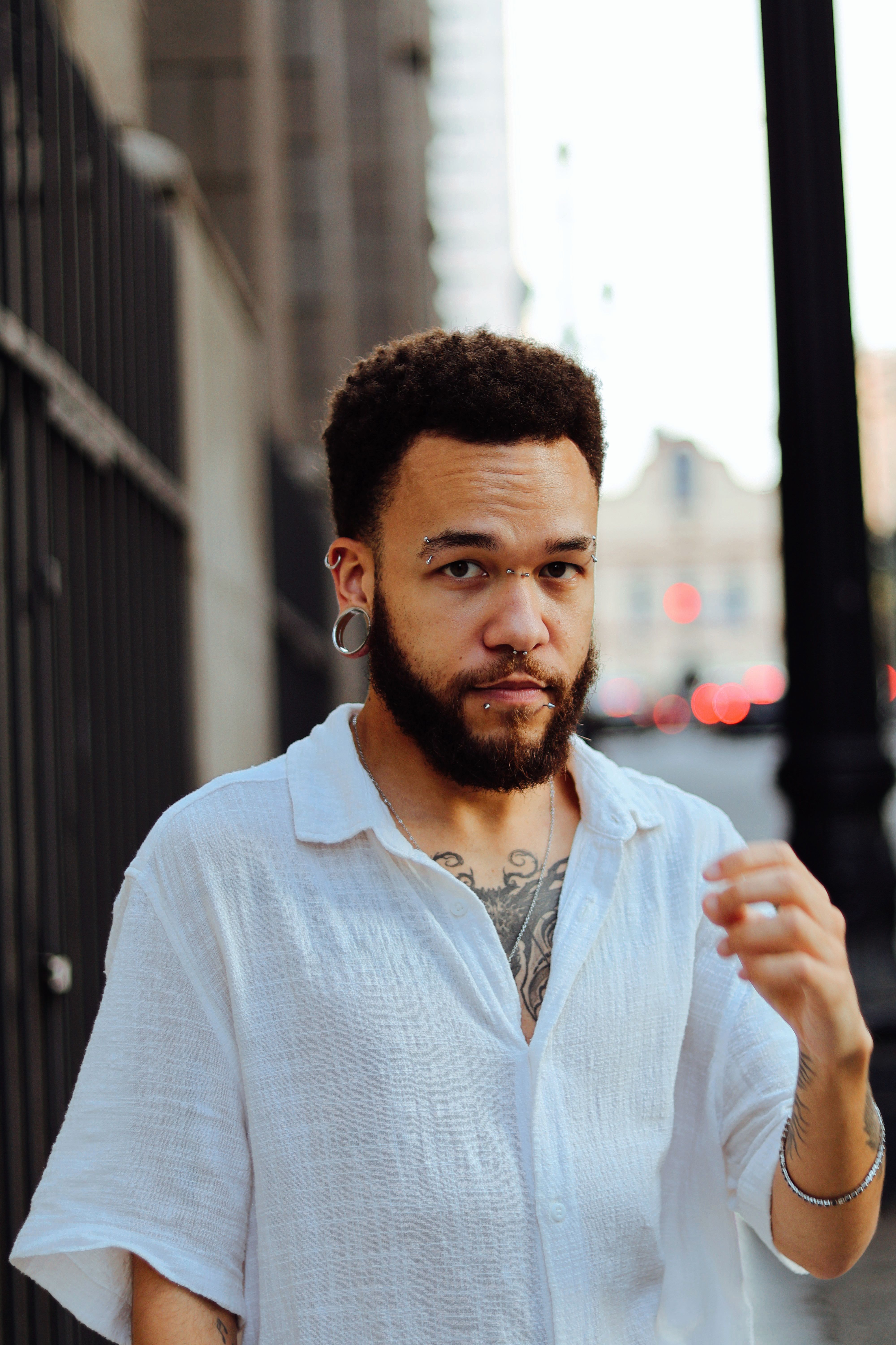 Urban portrait of a young man in a casual white shirt on a São Paulo street.