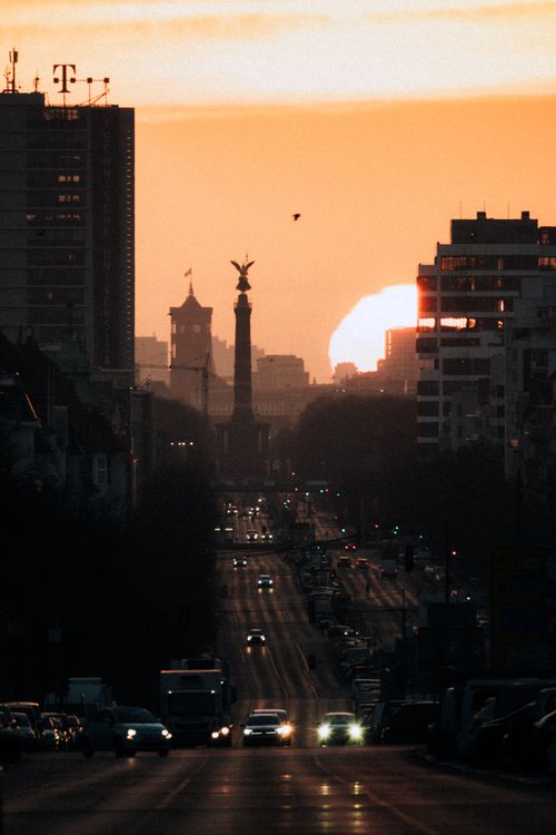 Free Dramatic view of Berlin's Victory Column silhouetted against a vibrant sunset, showcasing urban beauty. Stock Photo