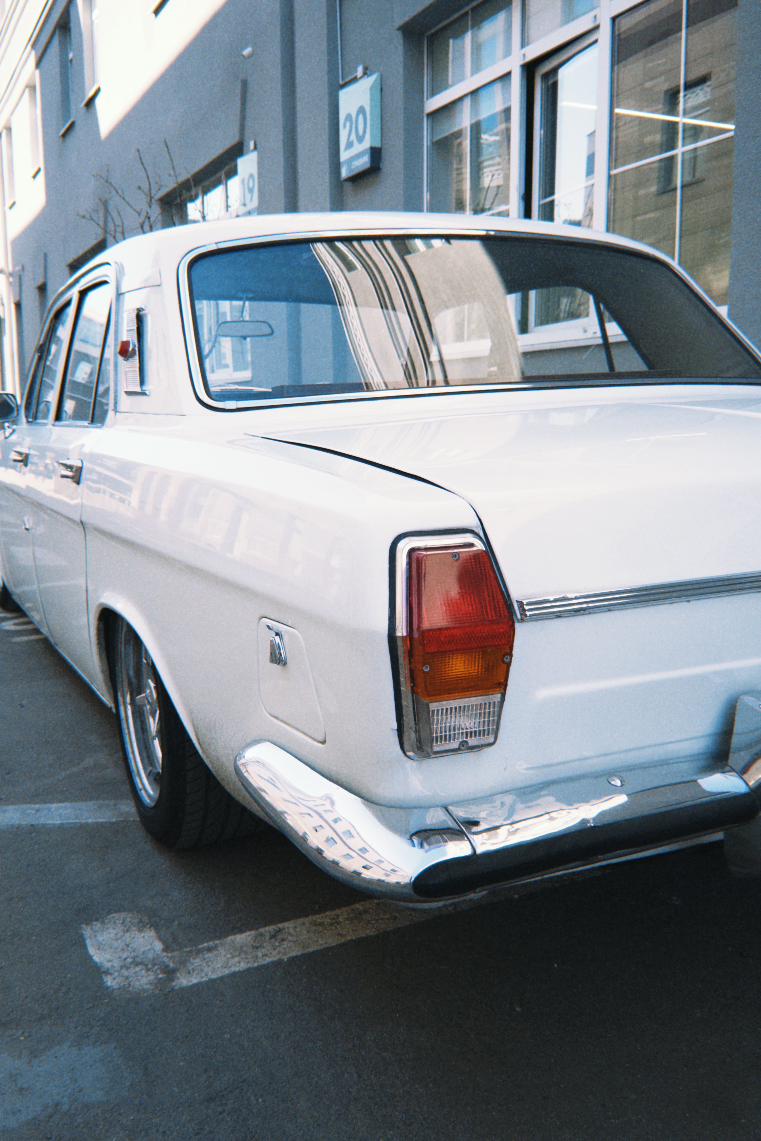 A classic white car parked outdoors on a street in Moscow, Russia, showcasing retro automotive design.