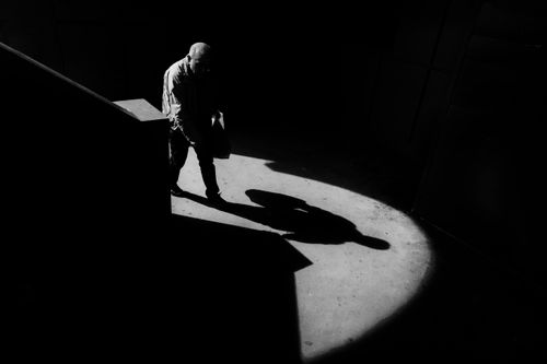 Free A striking black and white image capturing a man's silhouette under a spotlight. Stock Photo