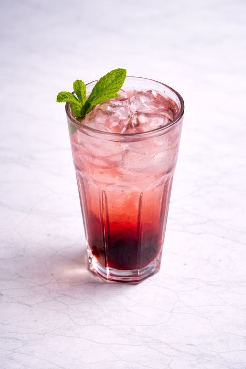 Free Delicious iced berry mocktail garnished with fresh mint leaves, perfect for summer refreshment. Stock Photo