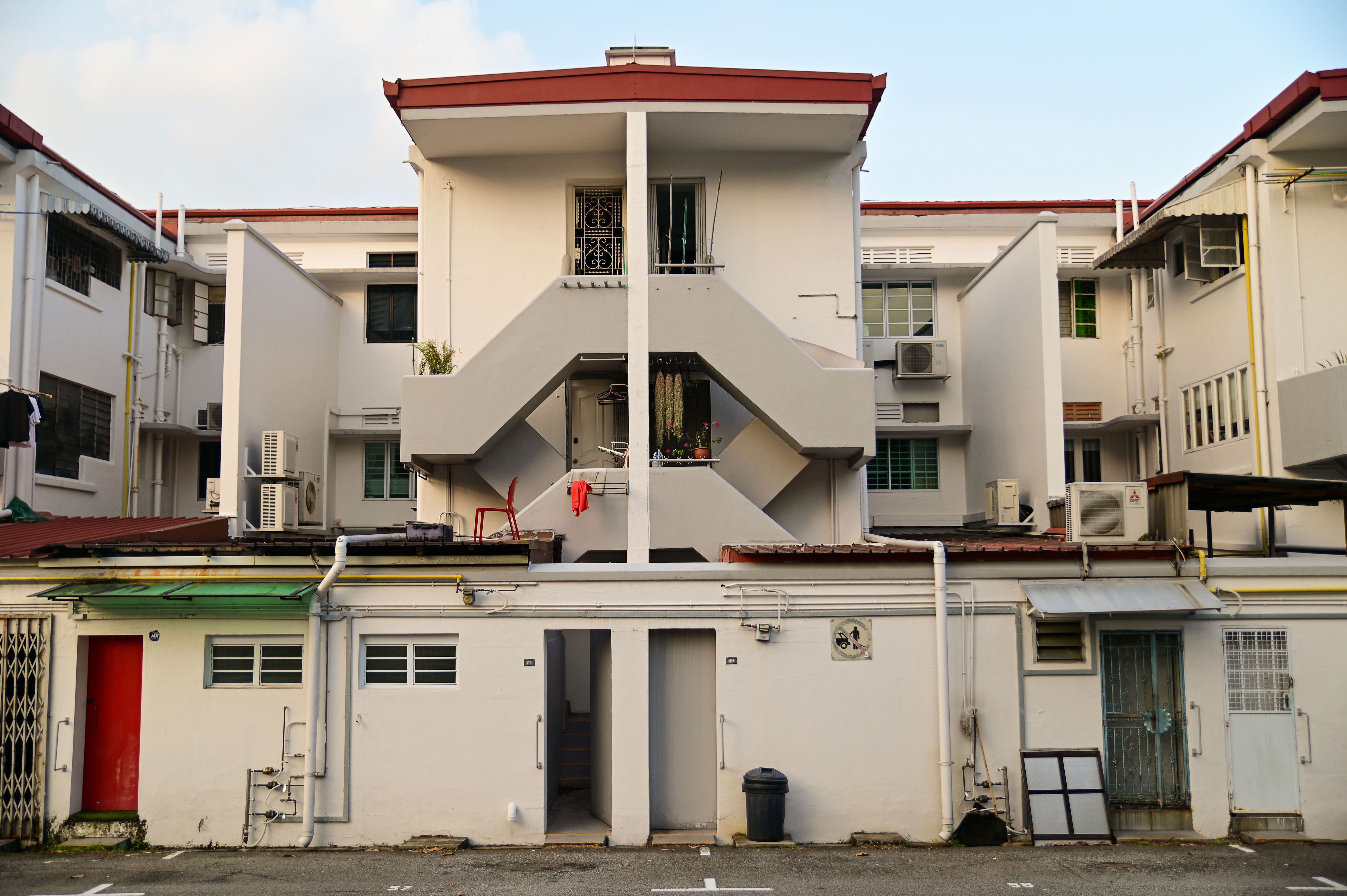 Street view of art deco apartments in Tiong Bahru, showcasing unique architectural style.