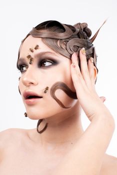 Creative fashion portrait featuring a woman with artistic makeup and bees on her face.