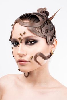 Conceptual portrait of a woman with an artistic hairstyle and bees on a white background.