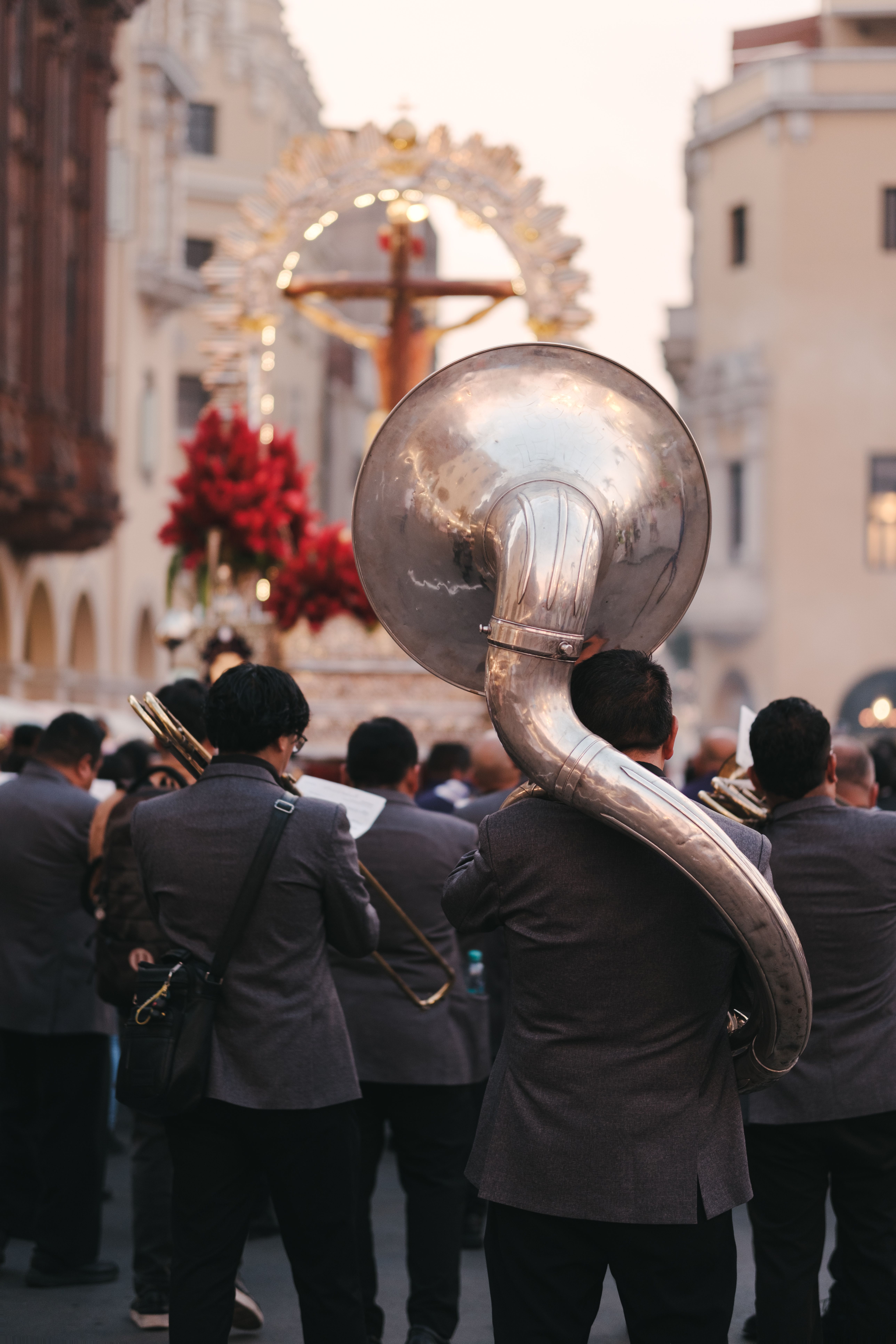 Musicians parade through city streets with instruments during a cultural festival.