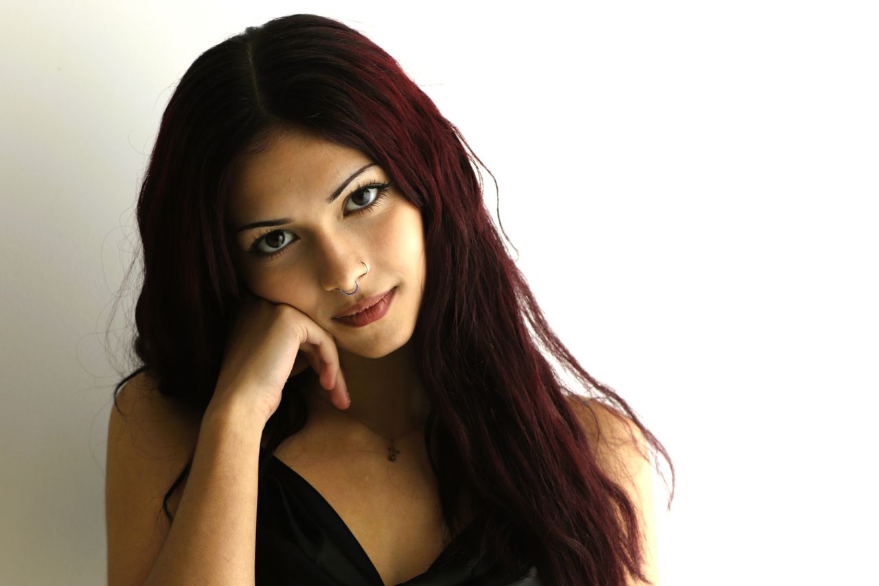 a close up portrait of a young woman with red hair thoughtful expressi