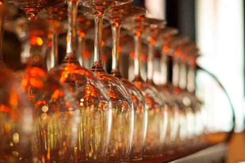 Free Elegant display of upside-down wine glasses with a warm glow creating a refined atmosphere. Stock Photo