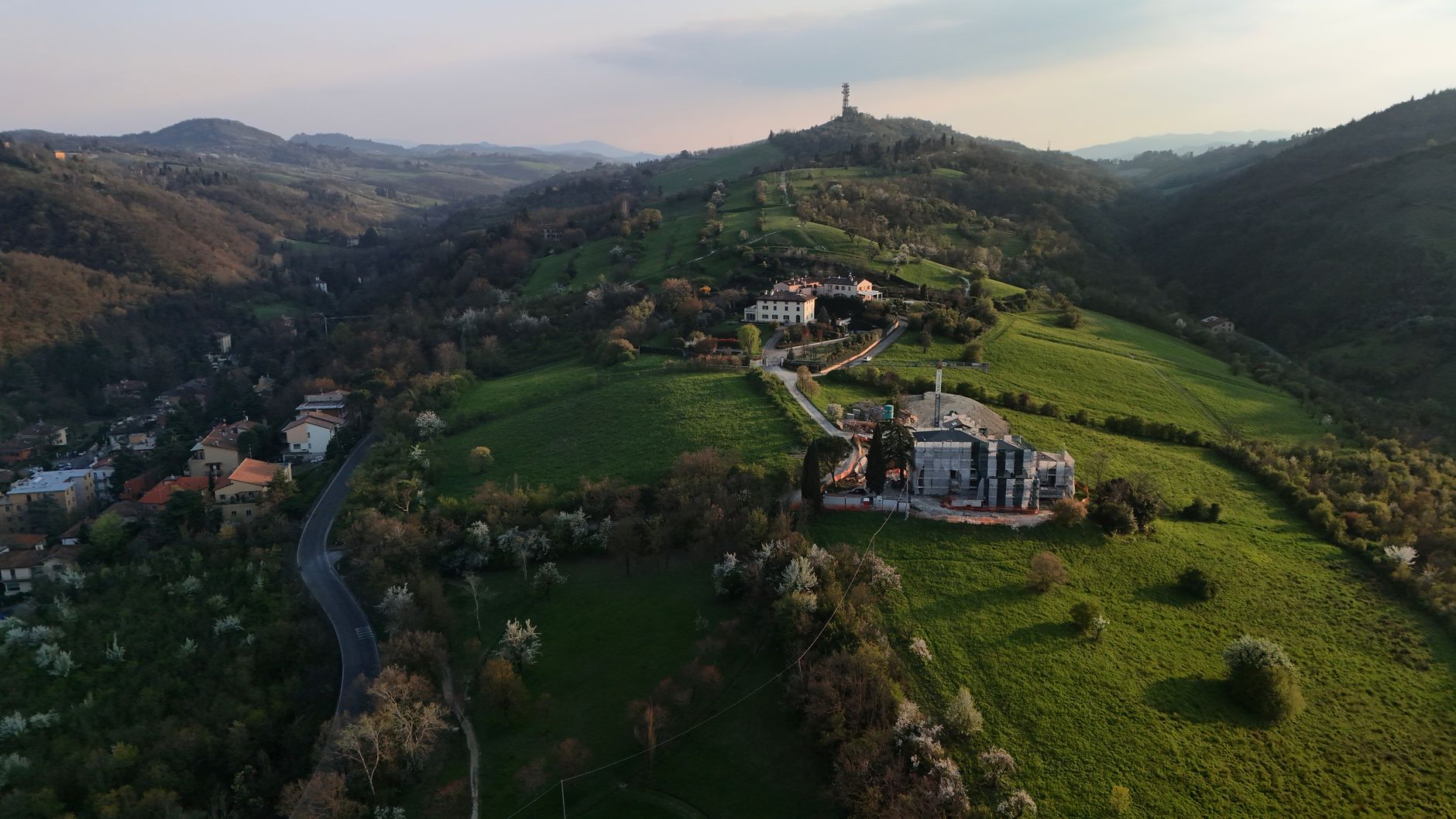 Veduta aerea delle colline verdi nei dintorni di Bologna al tramonto.