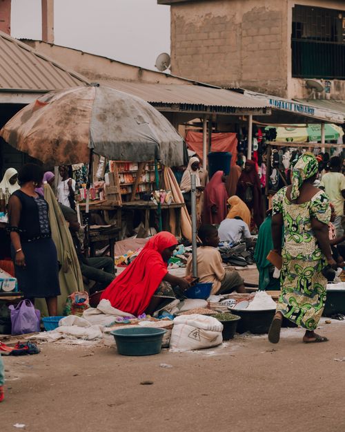 Free Lively outdoor market in Africa with people selling goods under umbrellas. Stock Photo